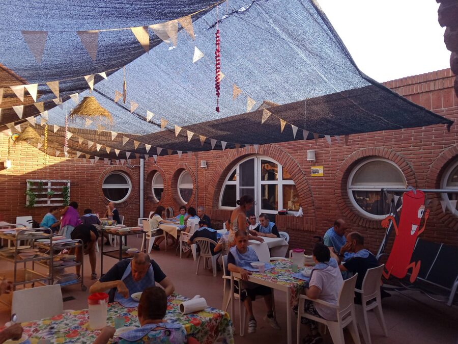 Persones usuàries d'APASA gaudint d'un dinar festiu a l'exterior de l'entitat per Sant Joan