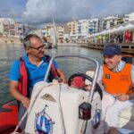 Usuari d'APASA navegant a una embarcació a motor amb personal del Club Nàutic de l'Ampolla